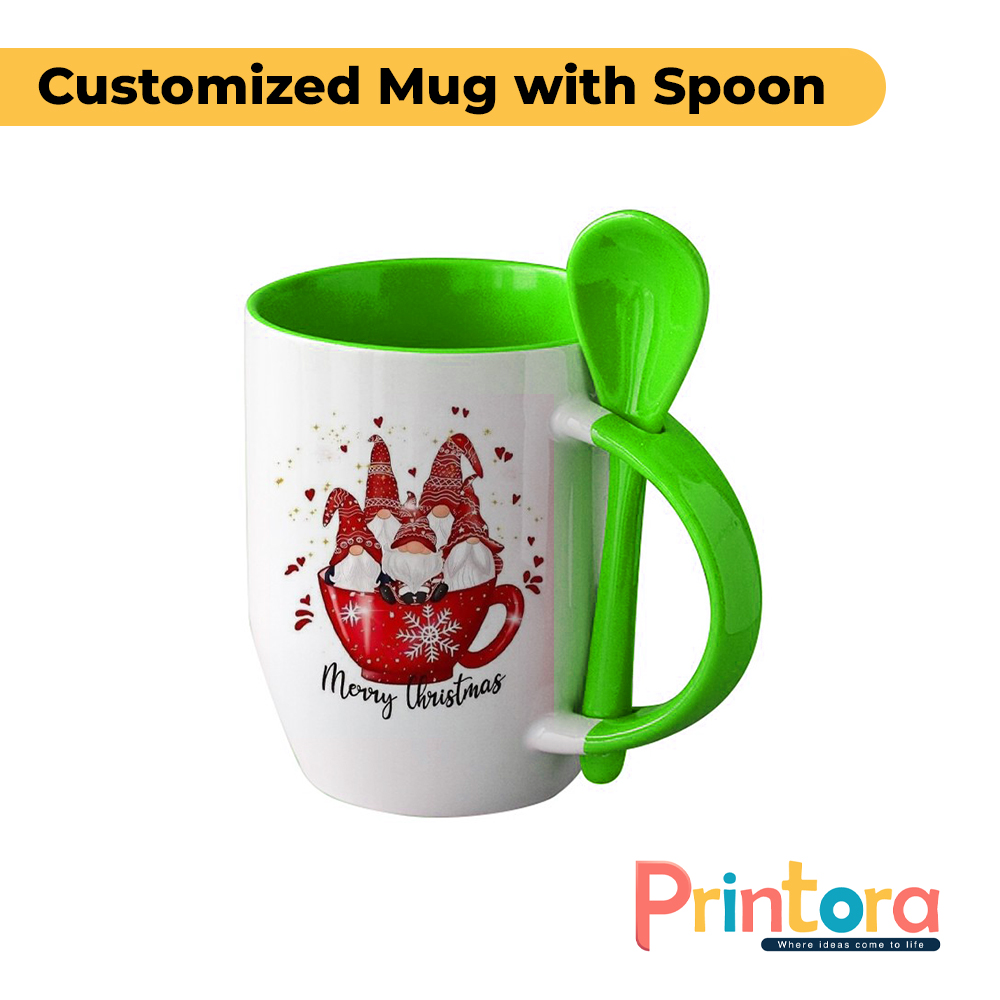 A white ceramic customized mug featuring a personalized photo print and a matching colored spoon inserted into the handle. The mug has a glossy finish and is designed for gifting and everyday use in Pakistan.